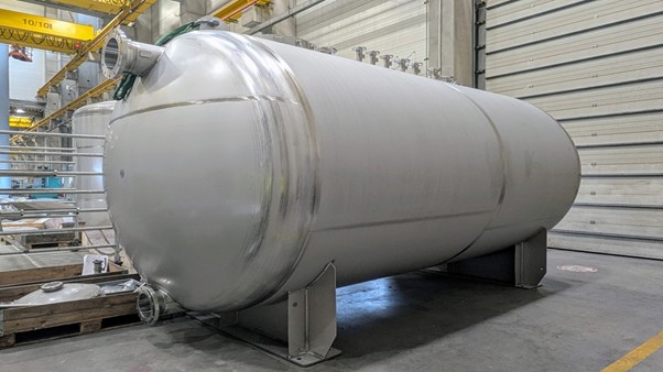 Stainless steel waste tank in a pharmaceutical production facility, used for industrial storage and processing.