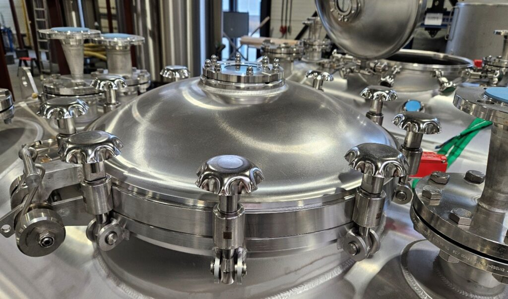 Stainless steel pharmaceutical waste tank with multiple valves and fittings for safe fluid control and compliant waste management.